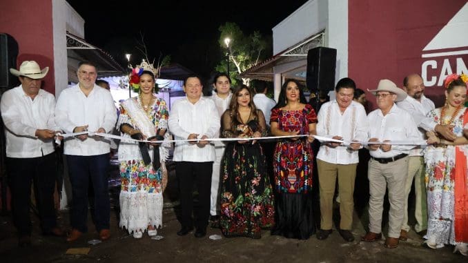 a group of people holding a ribbon at a nighttime ceremony for an opening event
