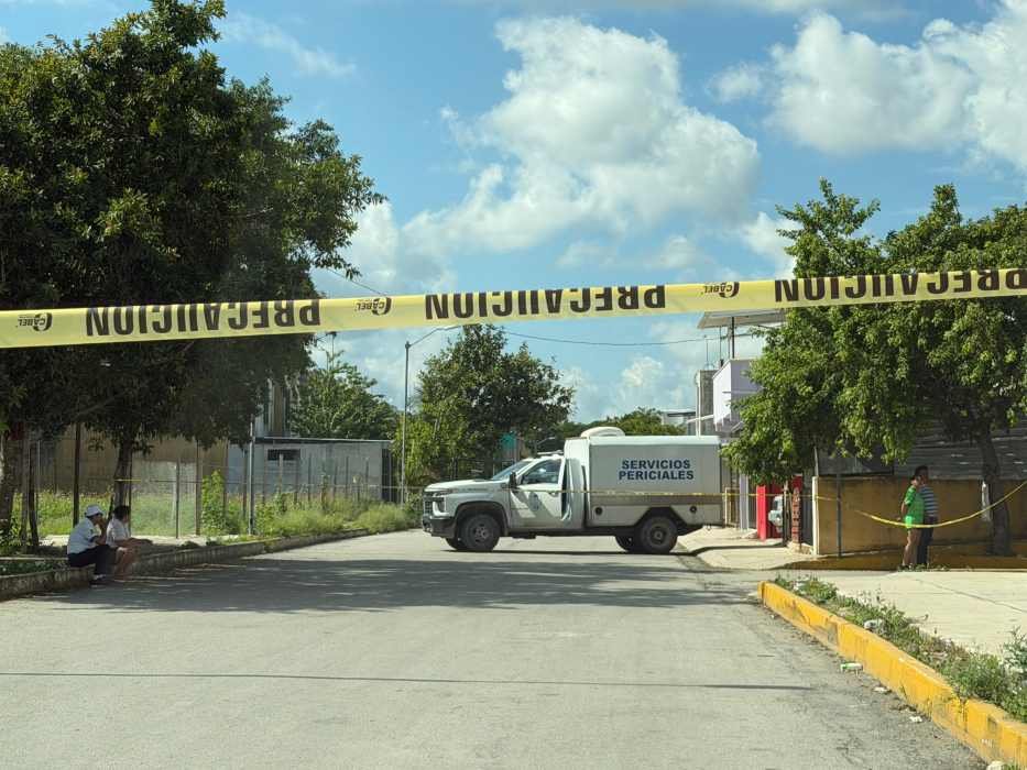 A street blocked by caution tape, with a forensic services truck and people nearby sitting and standing under trees-18112025