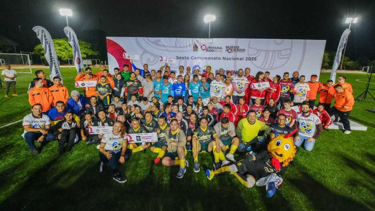 a large group of participants and supporters gather on a soccer field for a group photo at night during the sixth national championship 2025 event