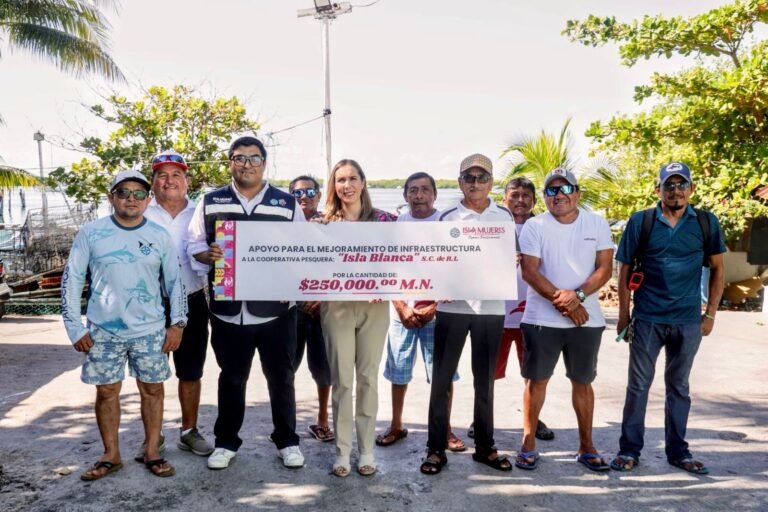 A group of people holding a large check for financial support to a fishing cooperative.