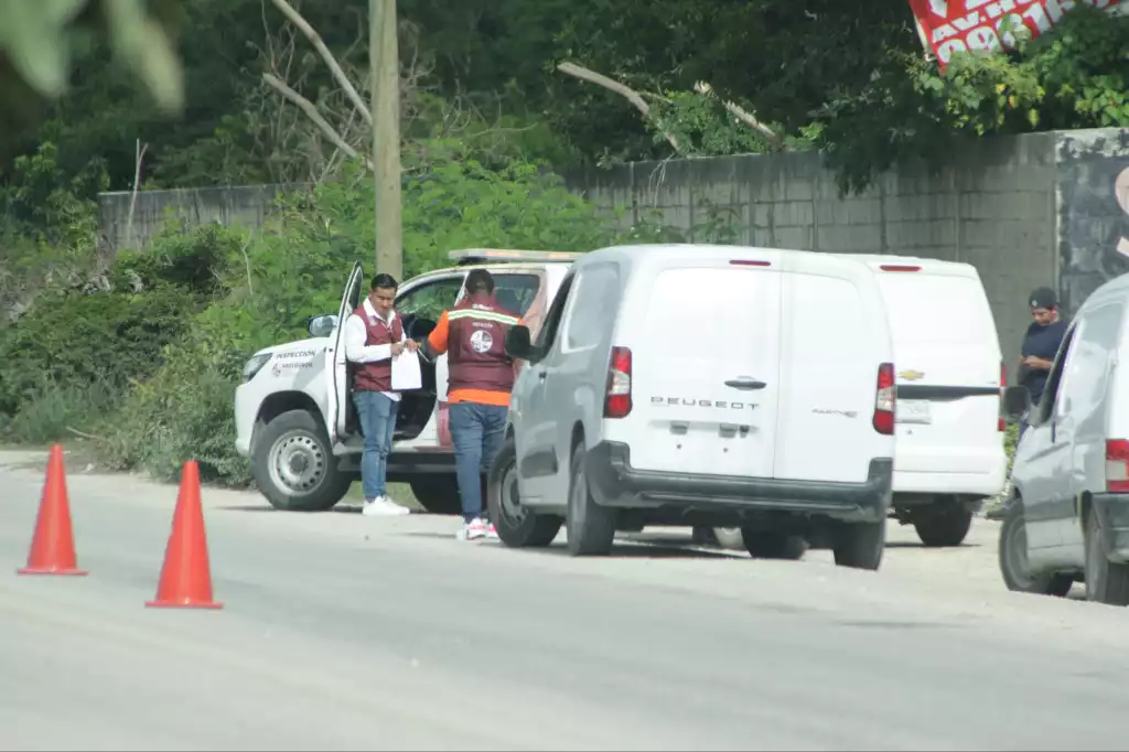 officers conducting a vehicle inspection on the roadside with traffic cones visible-28112025