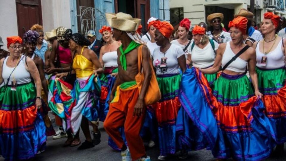 a group of people in colorful traditional costumes participate in a lively parade in a street-25112025