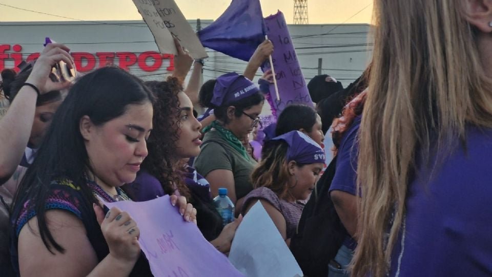 group of women participating in a protest wearing purple clothing and holding signs
