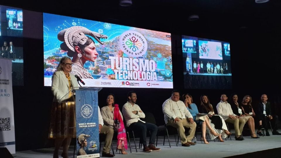 A speaker presenting at the World Tourism Trends Summit with a colorful screen behind displaying tourism and technology themes