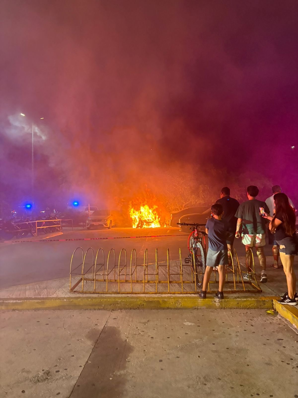 A car engulfed in flames in the parking lot of Plaza Las Americas in Playa del Carmen