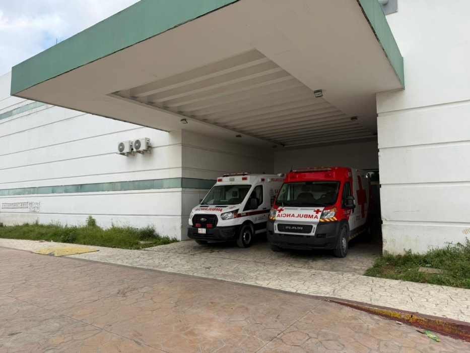 Paramedics providing medical assistance to an elderly man lying on the ground after an attack in Cancún