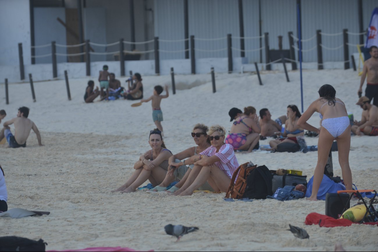Strong waves crashing on a Cancún beach with red flag warning signs visible