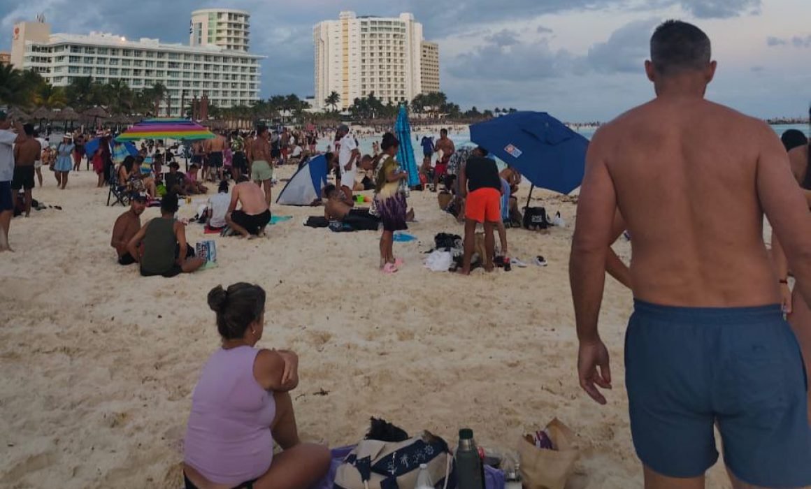 Crowded Cancún beach with families and tourists enjoying the final holiday weekend