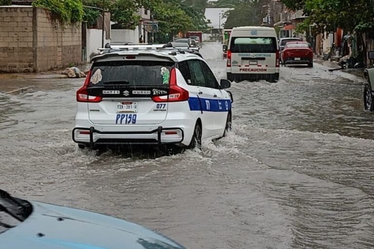 Flooded street in Playa del Carmen showing vehicles partially submerged in water