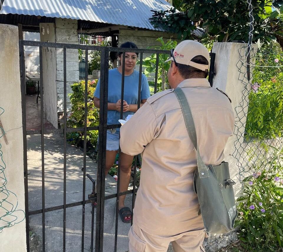 Health worker conducting door-to-door fever screening in a Quintana Roo community