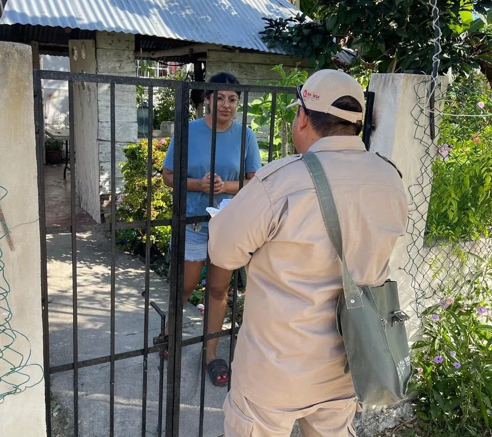 Health worker conducting door-to-door fever screening in a Quintana Roo community
