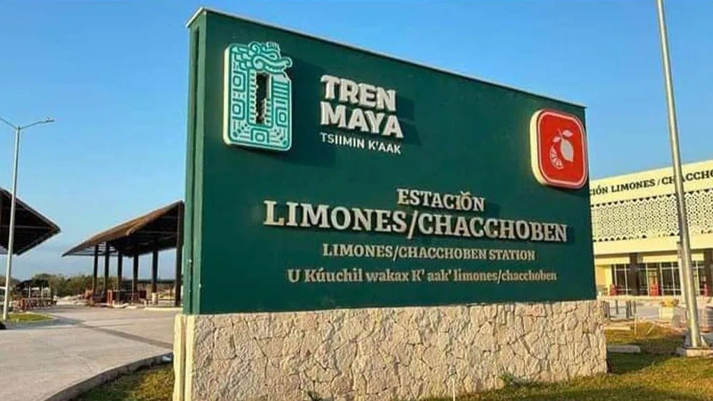 Workers at a Maya Train station holding signs about workplace harassment