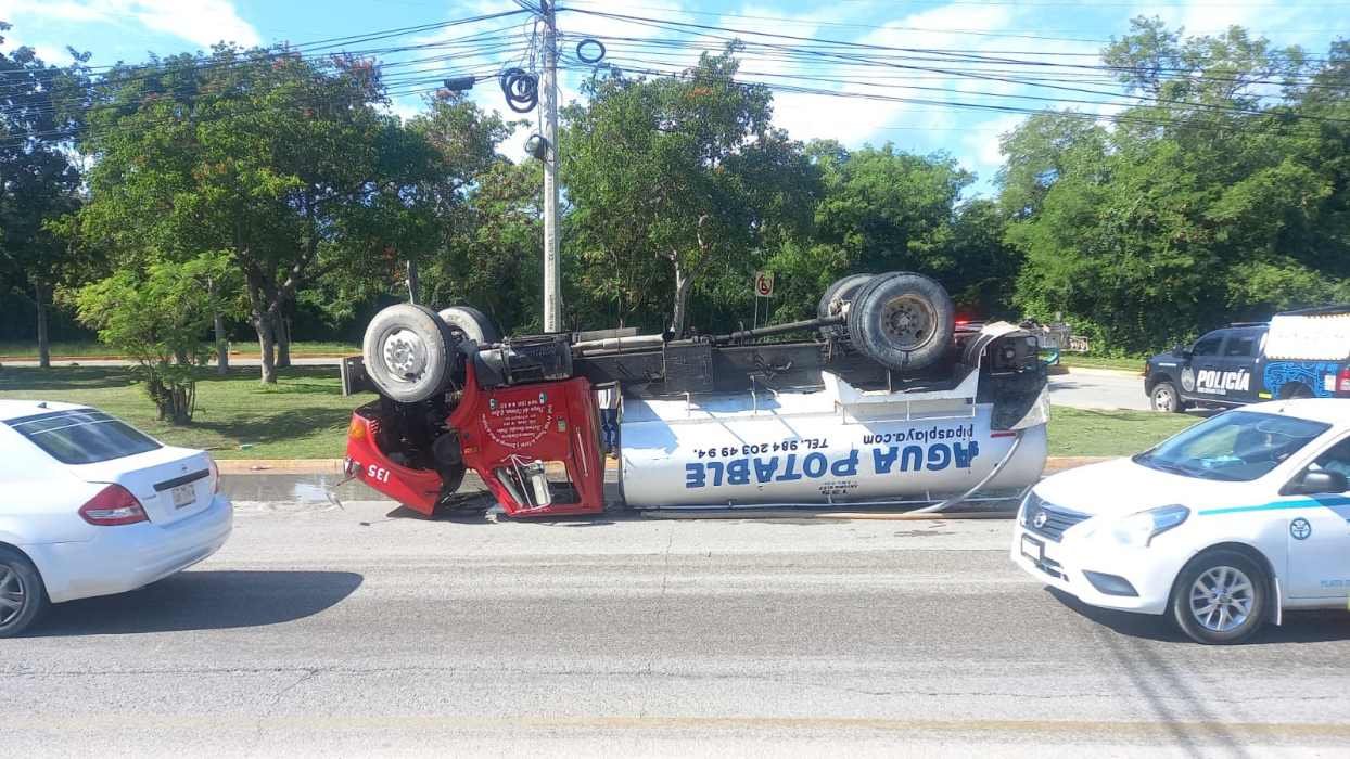 An overturned tanker truck lying on its side on Federal Highway 307 at the entrance to Playa del Carmen