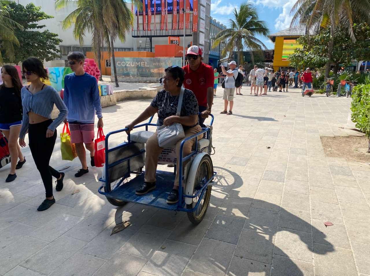 A tricycle operator transporting passengers in Playa del Carmen
