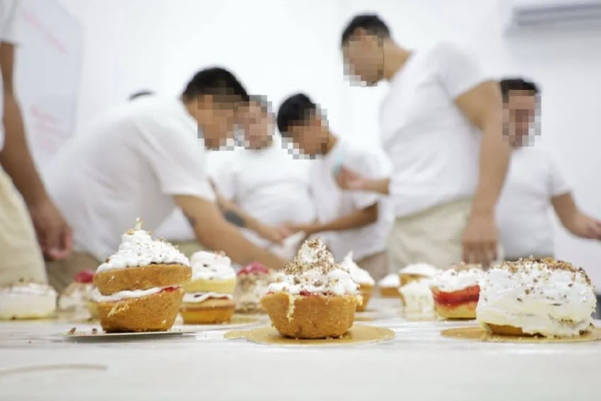 A group of male prisoners learning culinary skills in a kitchen during January 2026