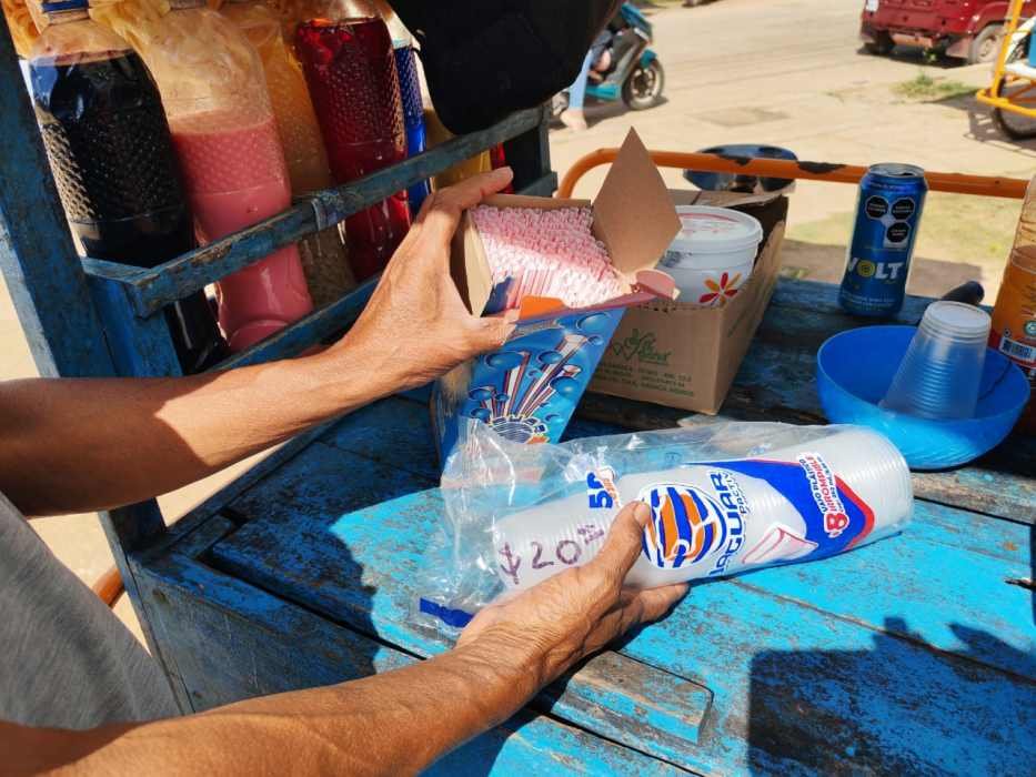 A vendor in José María Morelos holds a cup, illustrating the shortage affecting local businesses.