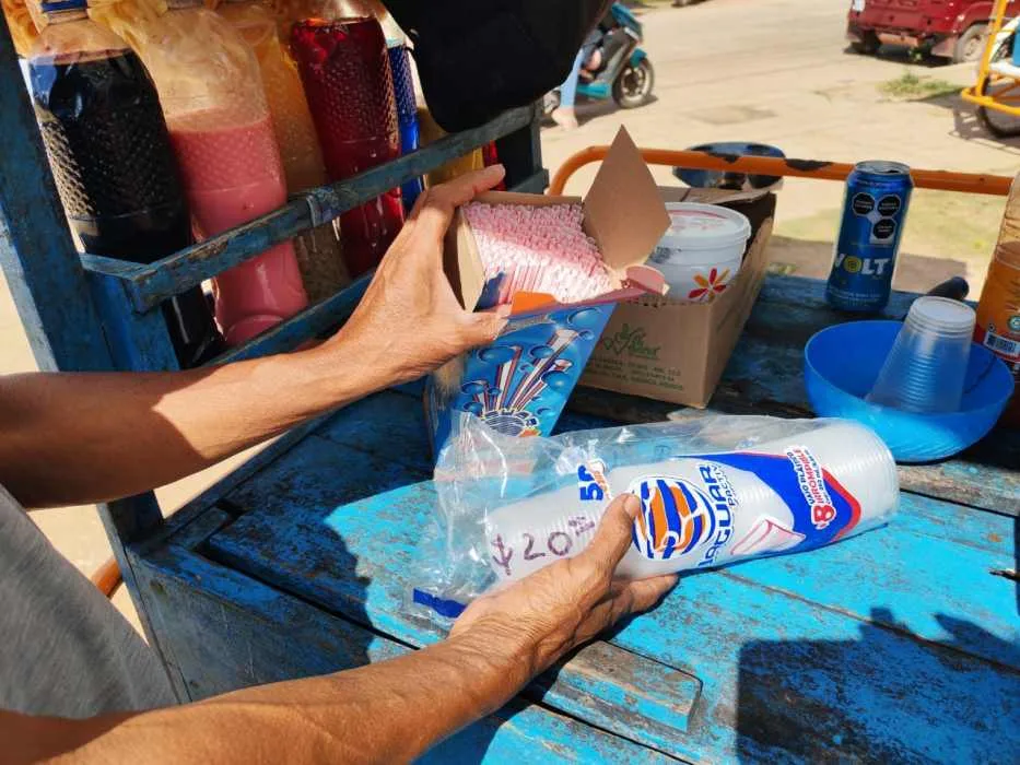 A vendor in José María Morelos holds a cup, illustrating the shortage affecting local businesses.