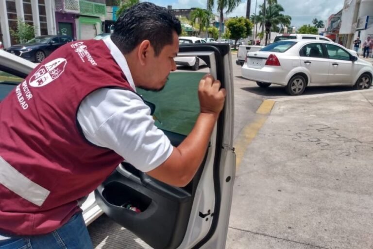 A vehicle with dark window tinting parked on a street