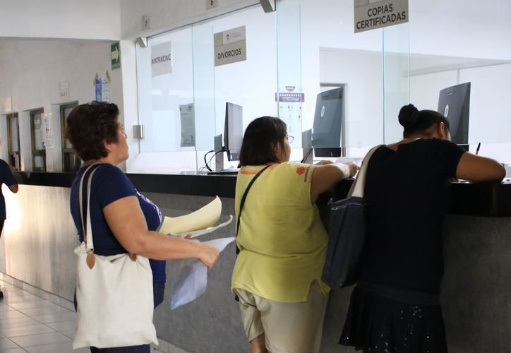 A person holding a certified birth certificate at a registry office in Cancún