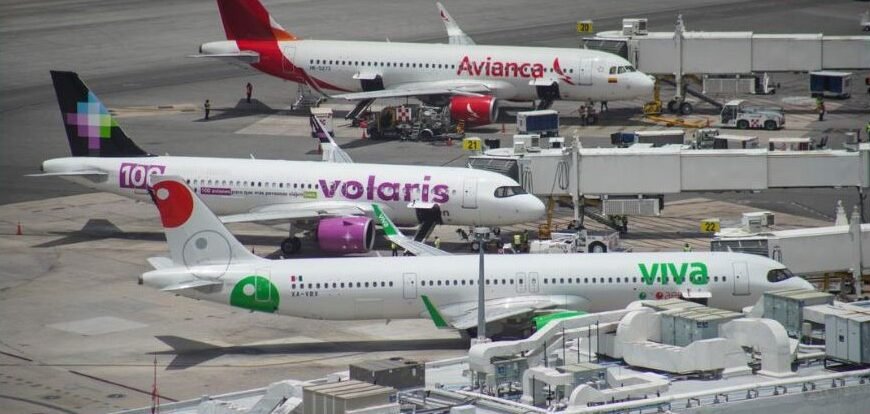 Exterior view of Cancún International Airport terminal building with palm trees