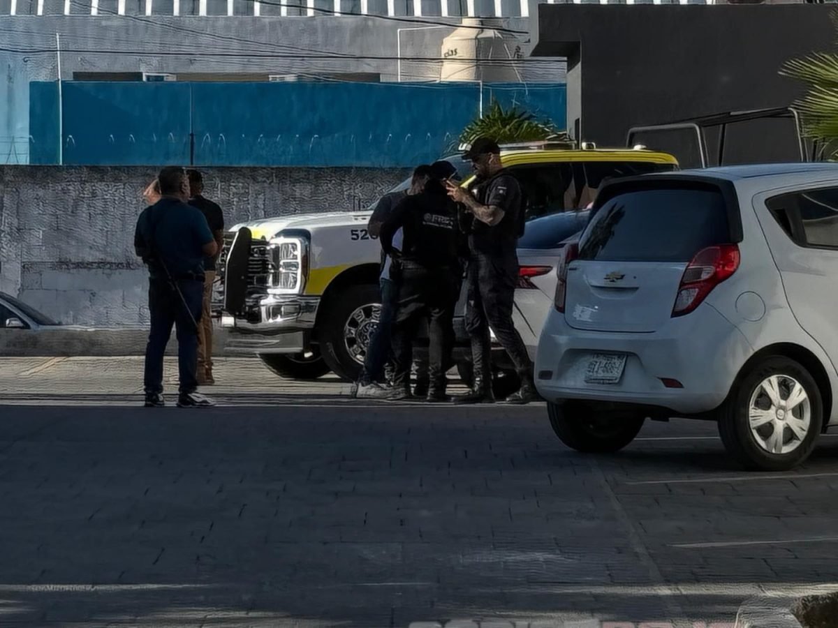 Police and investigators at the scene of an armed robbery in a Cancun restaurant parking lot