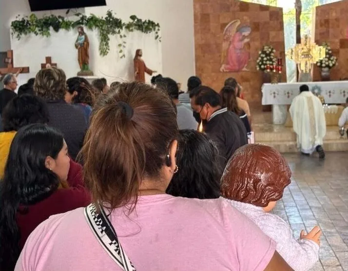Parishioners gather at a church in Cancún for Candlemas celebrations, holding candles and Baby Jesus figures