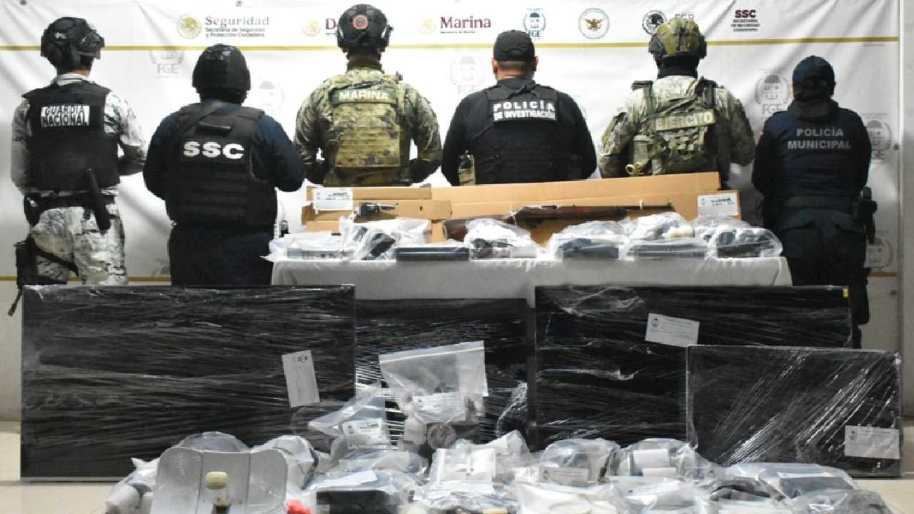 Law enforcement officers conducting a raid in Chetumal, with seized surveillance equipment visible