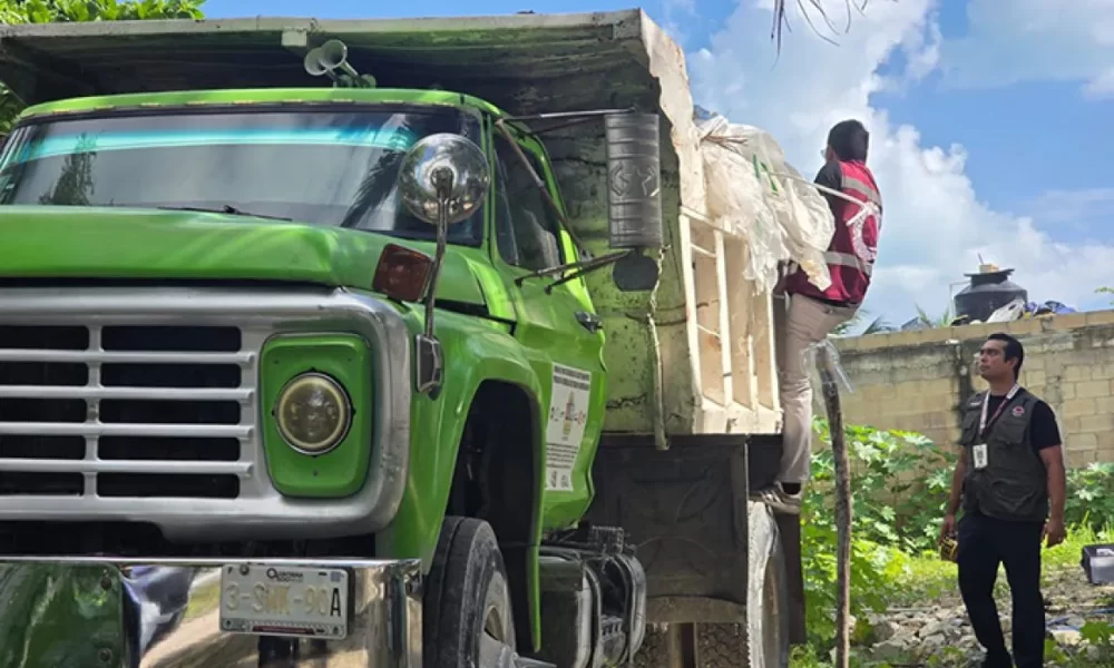 A dump truck in Quintana Roo, Mexico, with construction debris visible in the background