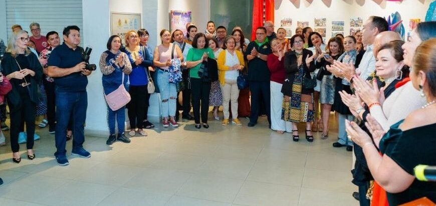 Attendees view the 'Between Feathers and Sequins' photo exhibition at the Museum of the Island in Cozumel.