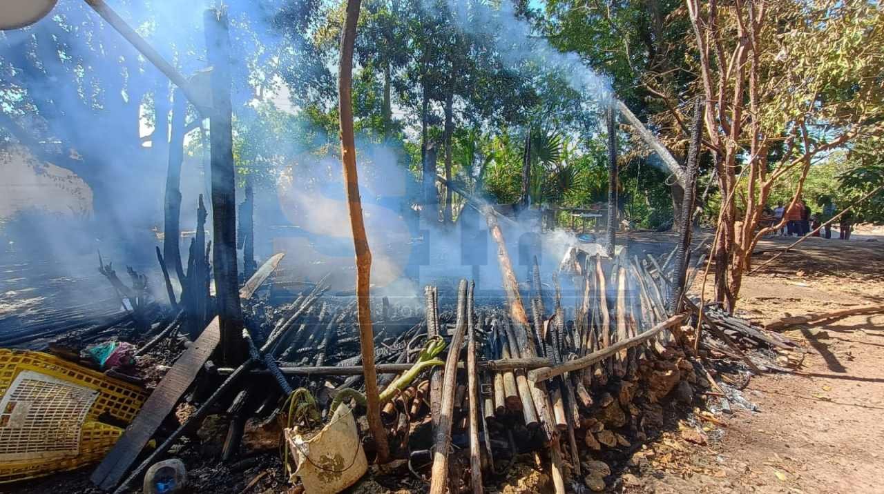 Firefighters extinguish flames at a destroyed home in Felipe Carrillo Puerto, Mexico