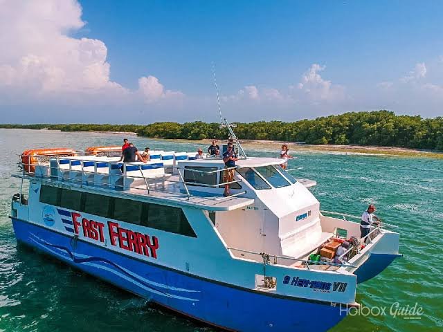A ferry boat docked at a pier with cloudy skies in the background