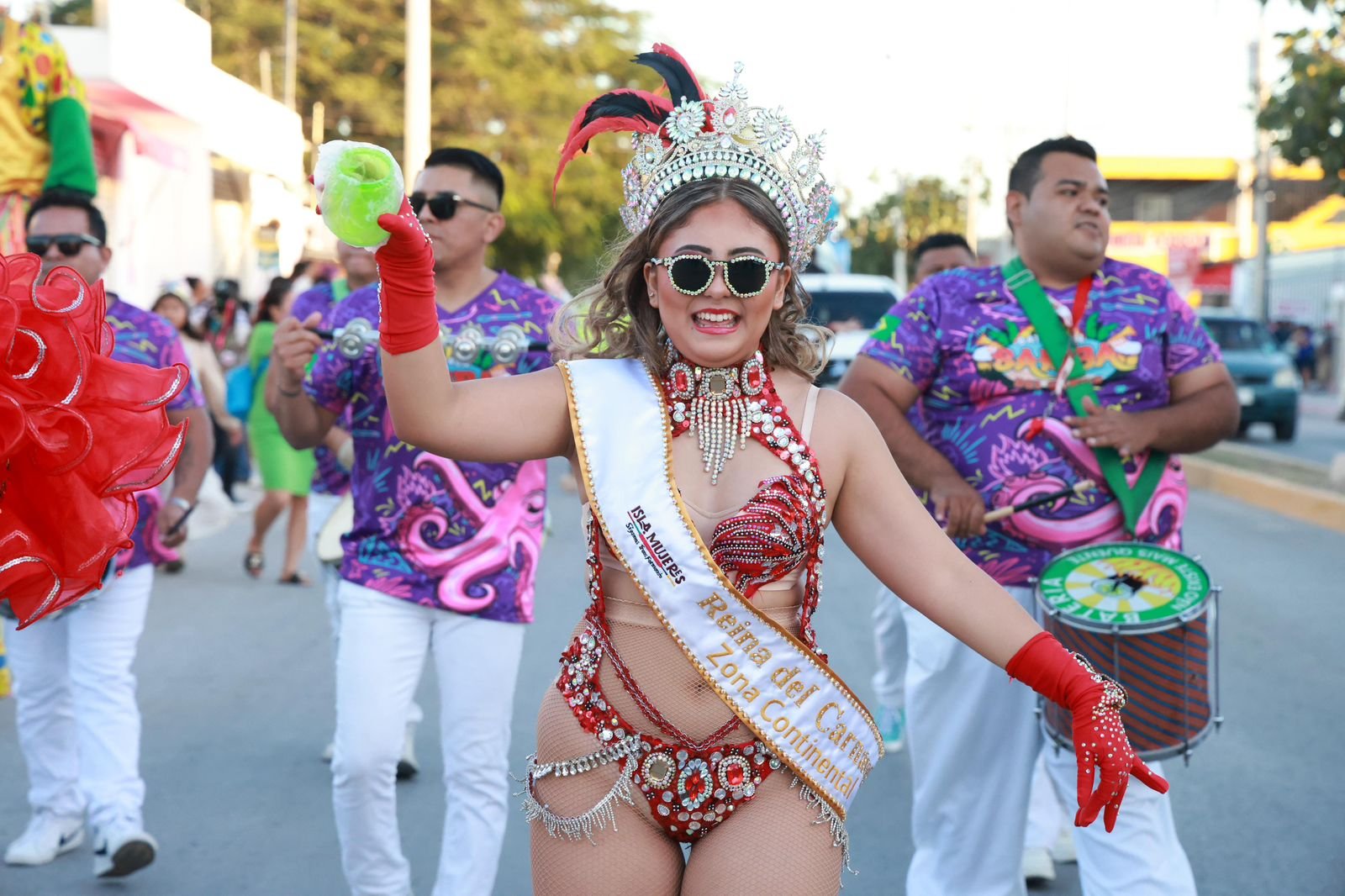 Colorful carnival parade floats and participants in Ciudad Mujeres, Isla Mujeres