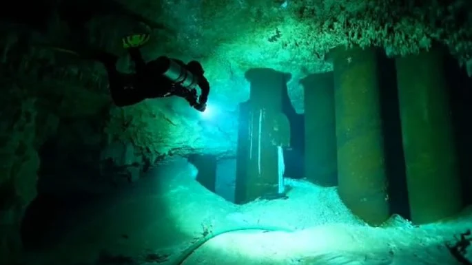 A diver inspects a crumbling concrete pillar supporting the Maya Train tracks in an underground river