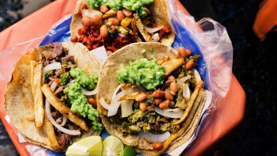 Colorful display of Mexican street food including tacos and elotes on a market stall
