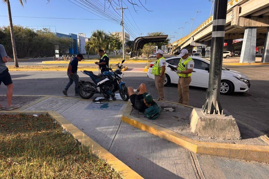 A damaged motorcycle lies on the ground after a collision with a car on Playa del Carmen Boulevard.