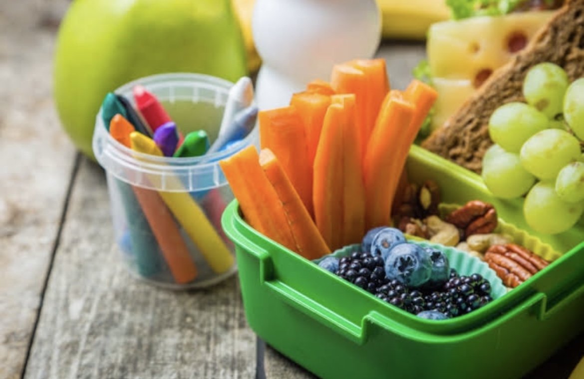 A group of parents holding signs advocating for healthier food options near schools in Quintana Roo