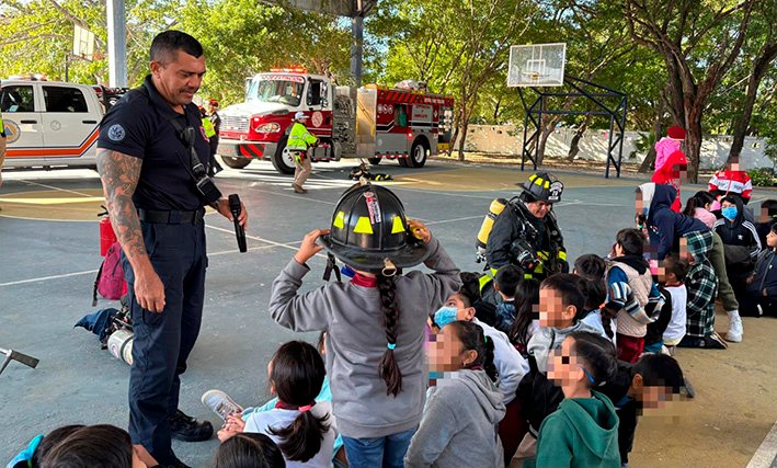 Civil protection officials and firefighters conducting a safety demonstration for students at a school in Playa del Carmen