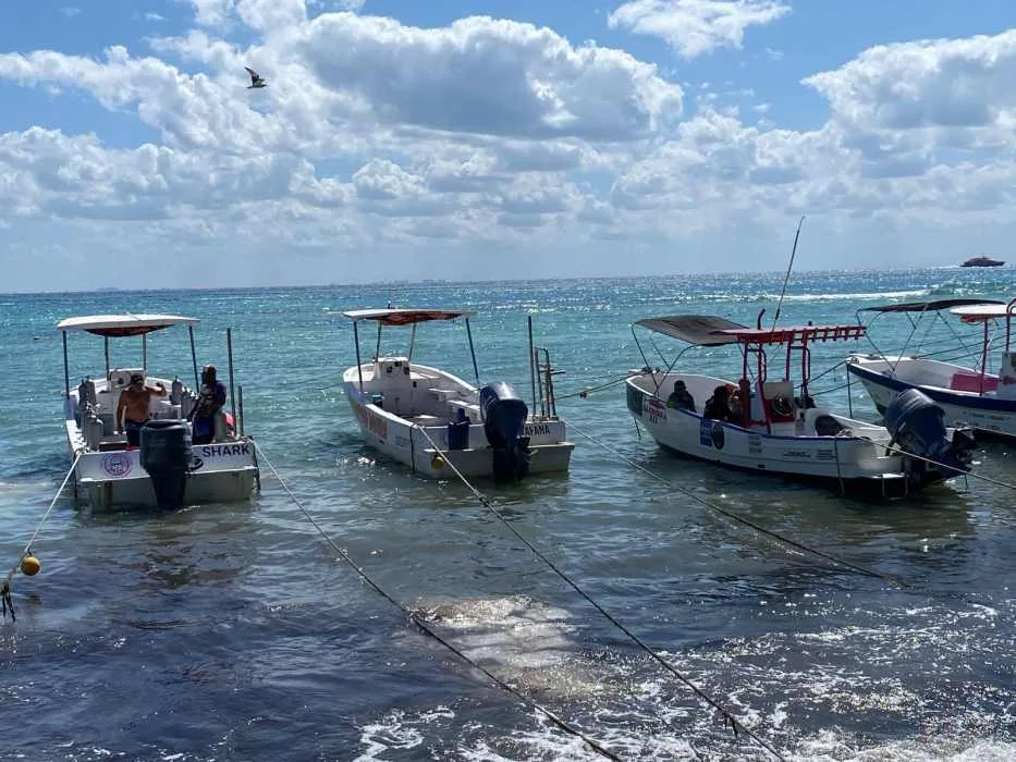 A tour boat dock in Playa del Carmen, Mexico, with boats moored along a pier.