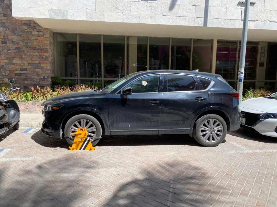 A view of a parking lot in Playa del Carmen, showing no designated spaces for people with disabilities.