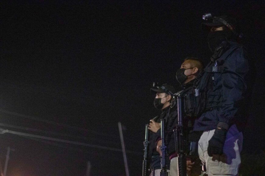 Police officers conducting an operation around an ADO bus on a highway in Felipe Carrillo Puerto, Quintana Roo