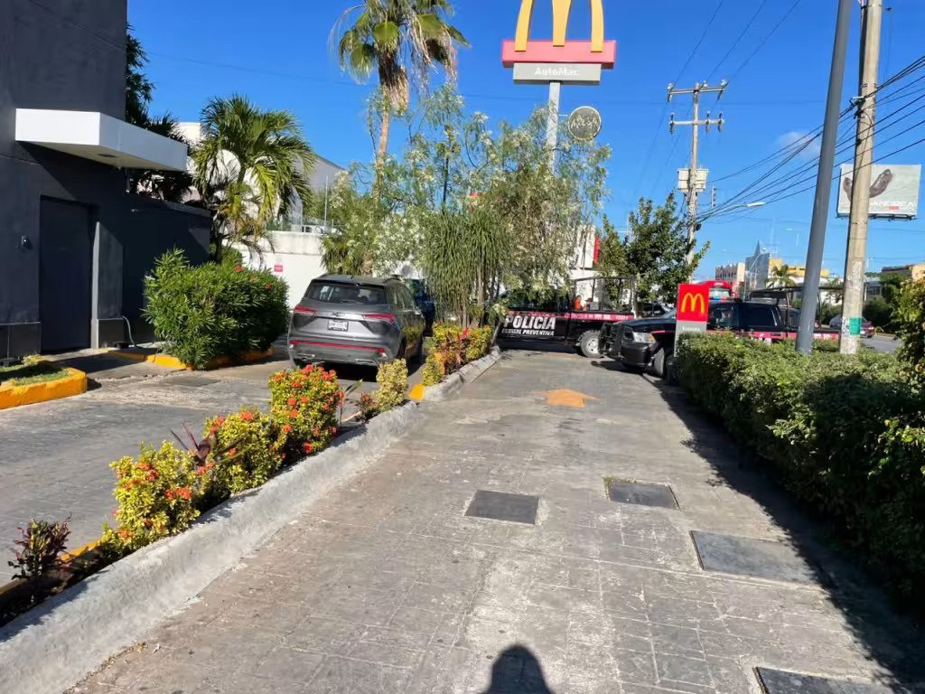 Police patrol vehicles parked outside a McDonald's restaurant in Cancún following an armed robbery