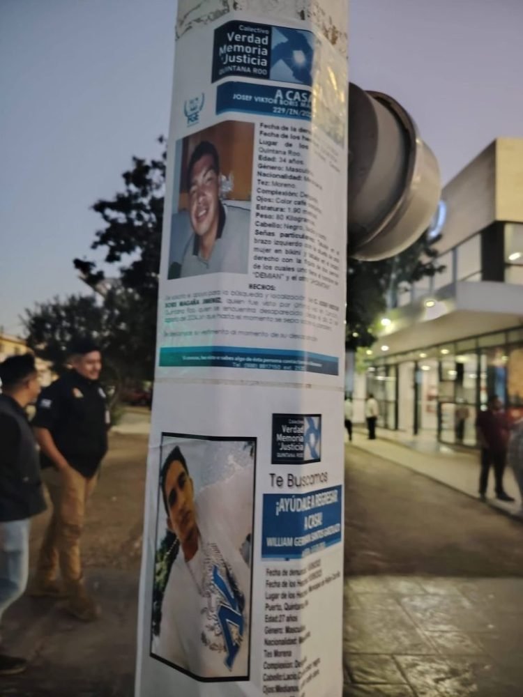 Members of the search collective posting flyers with photos and information about missing persons on a wall in Mérida