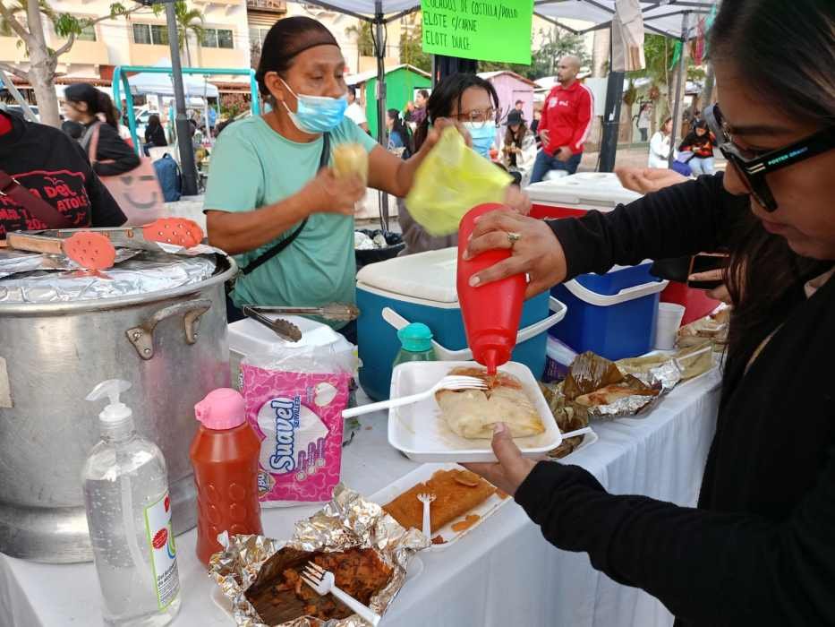 Crowds gather at the Tamal Festival in Playa del Carmen's 28 de Julio plaza, with vendors serving traditional Mexican tamales.