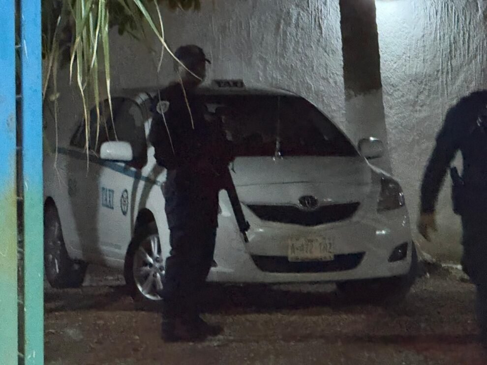 Taxi vehicle with bullet impacts secured at Puerto Aventuras taxi union after shooting incident
