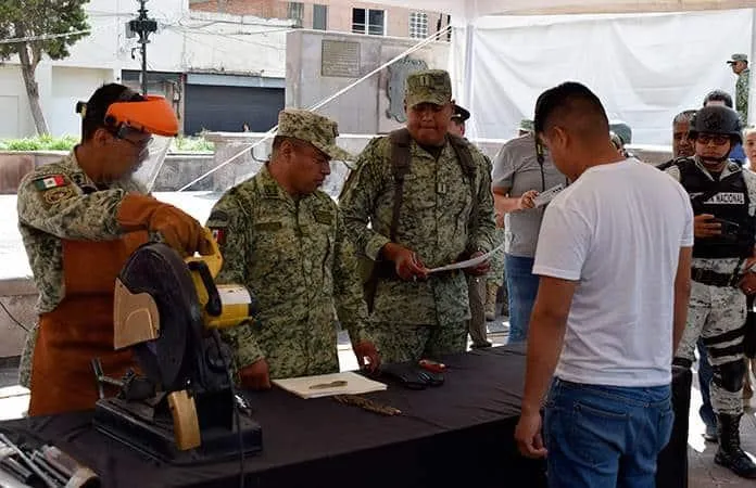 Officials and families participate in a toy gun exchange event in Chetumal, Quintana Roo