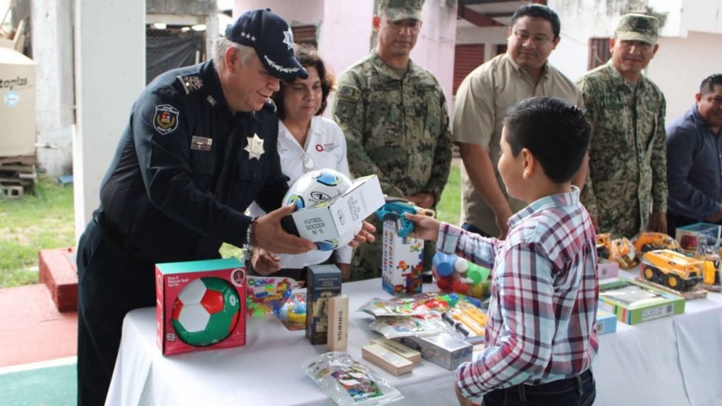Officials and children participating in a toy gun exchange program in Quintana Roo, Mexico