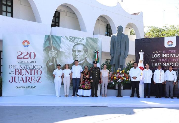 Officials and community members gather for a floral tribute during the Benito Juárez anniversary ceremony in Cancún