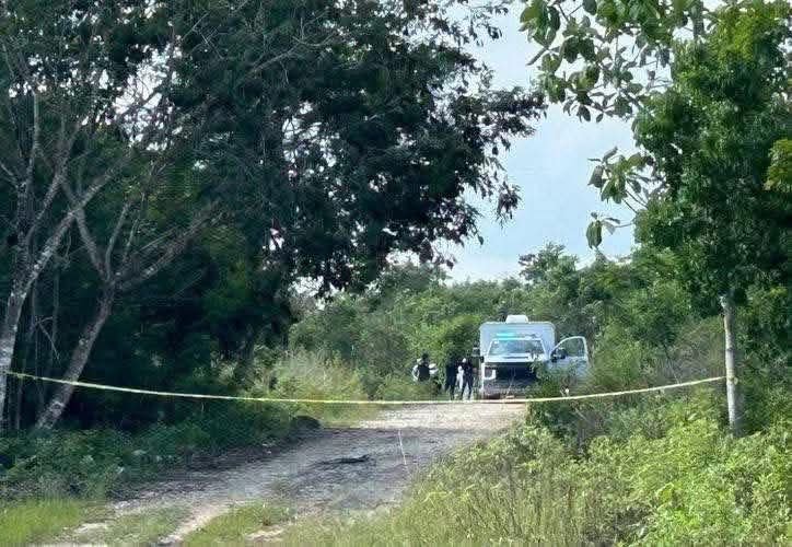 Police and forensic investigators at a crime scene on a dirt road near Calderitas, Quintana Roo