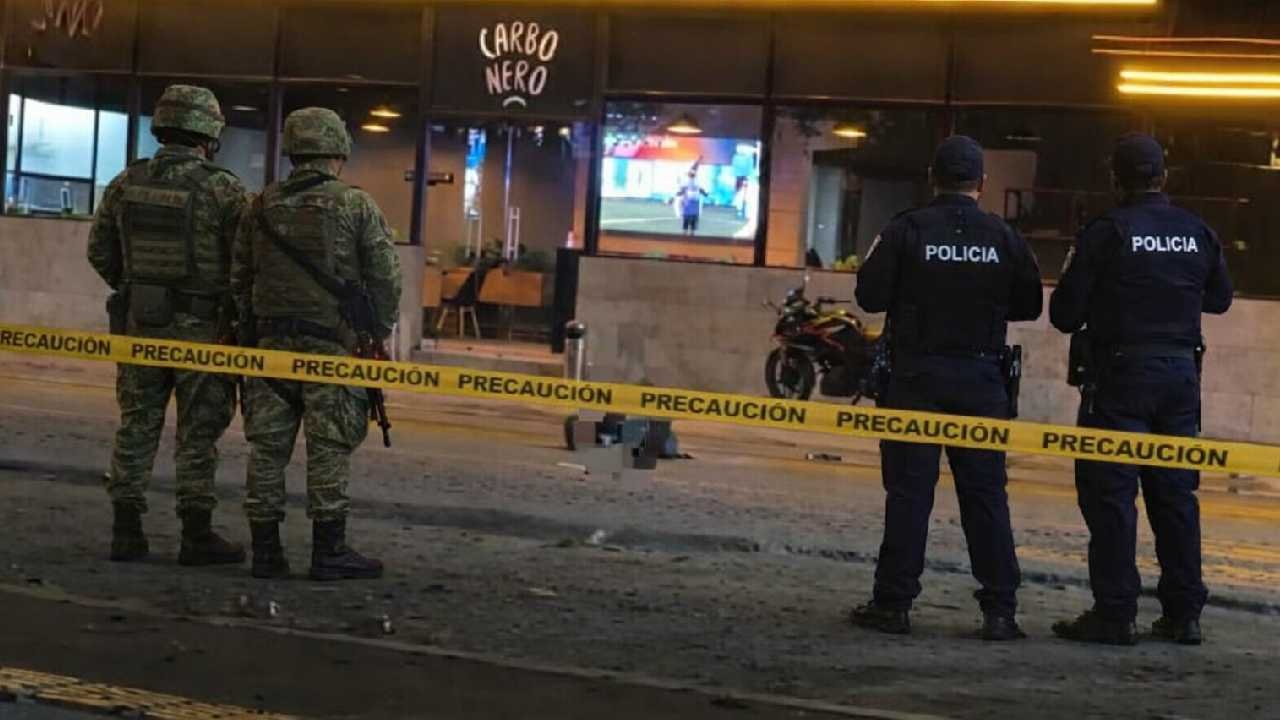 Police and emergency responders at the scene of a shooting outside a bar in Cancun