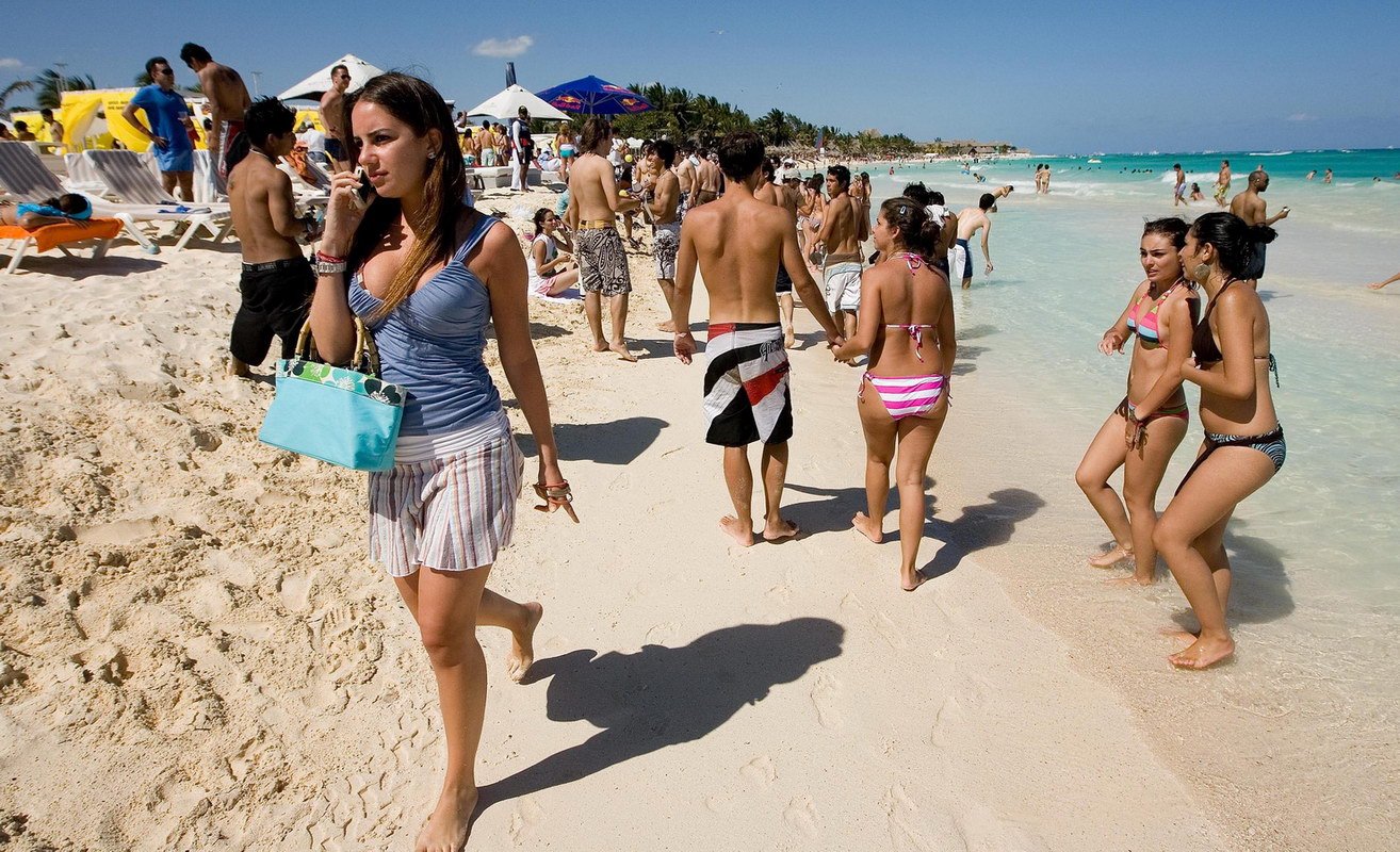 A view of a beach in Cancun, Quintana Roo, with turquoise waters and palm trees